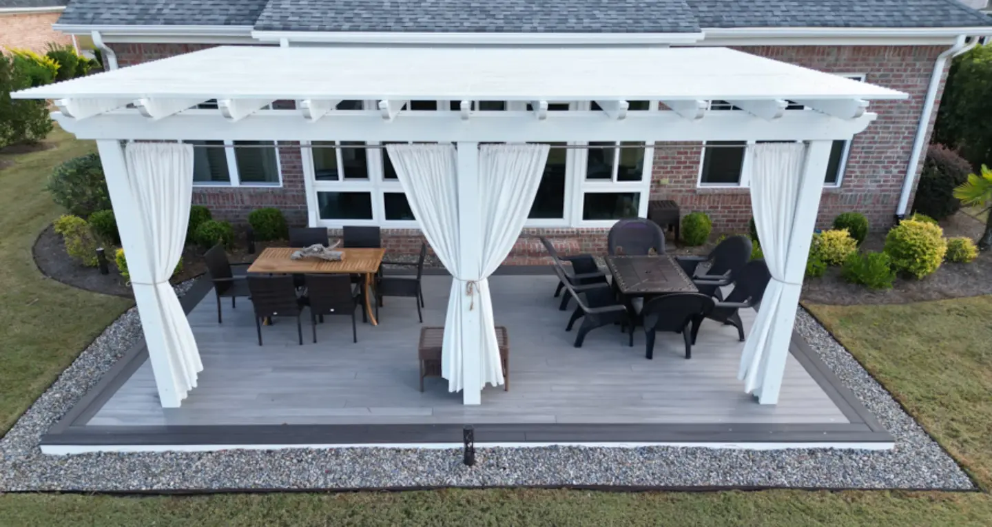 Backyard pergola with white curtains and patio furniture on the wilmington