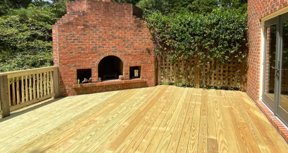 Custom wood deck with wood fence and railing with outdoor fireplace