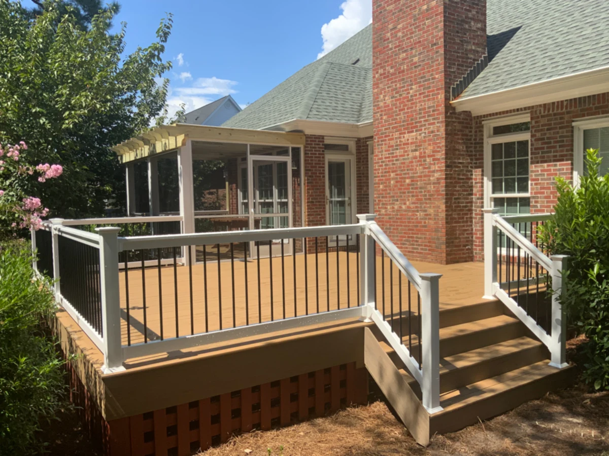 Elevated wood deck with railing and skirting featuring screened porch