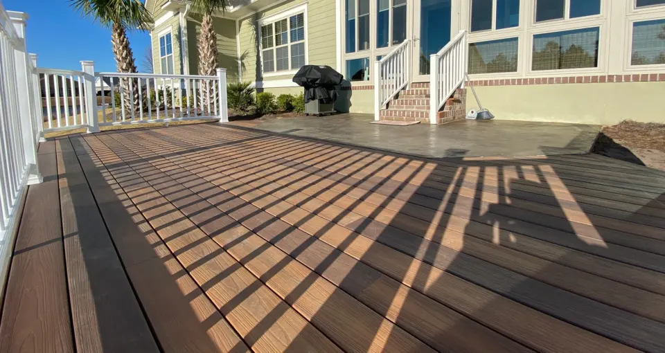 Hardwood decking backyard installation with white metal railing in wilmington nc