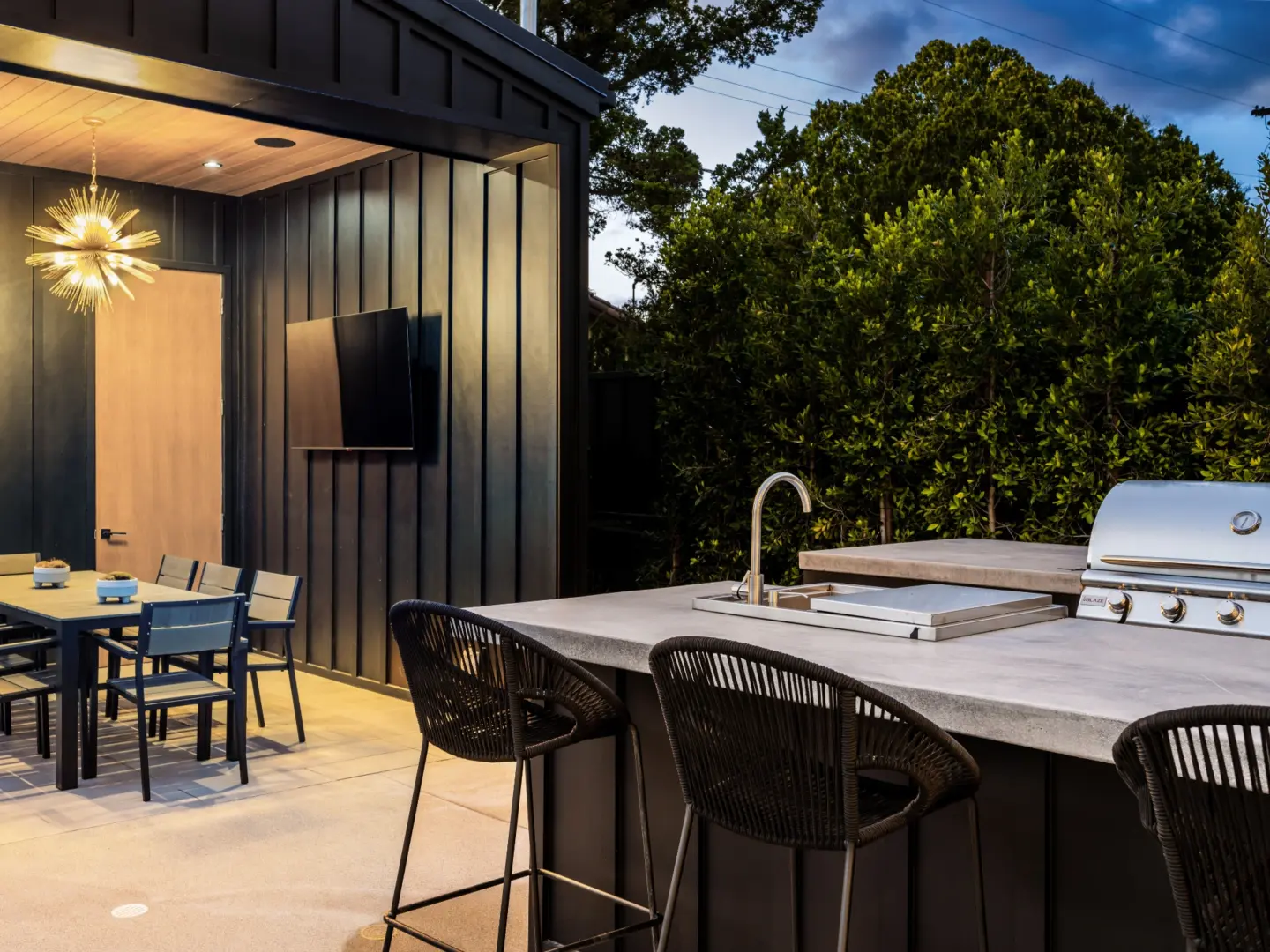 Modern outdoor kitchen and dining area with trees on the background in wilmington nc