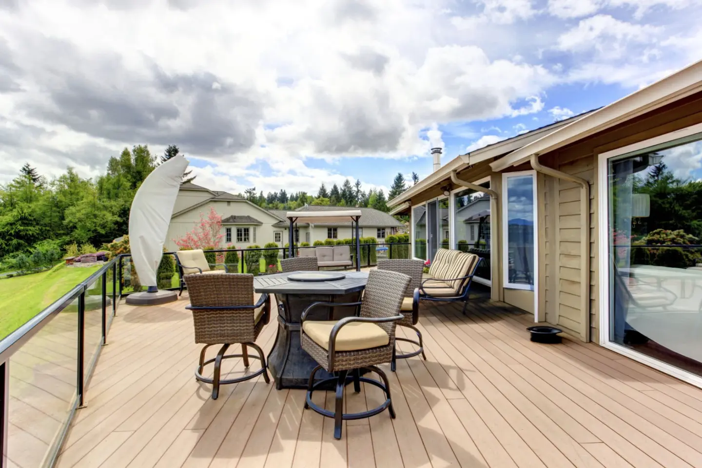 Patio area on the walkout deck with deck glass railing and outdoor furniture