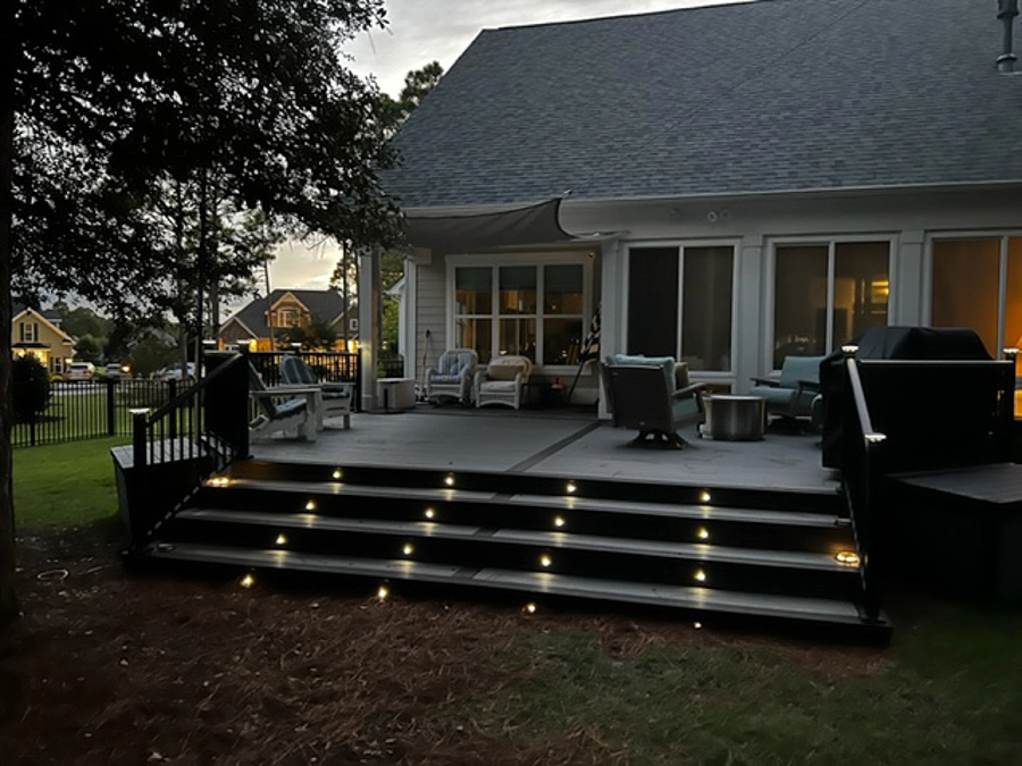 Pvc deck with lights on stairs with black metal railing and fence in wilmington nc