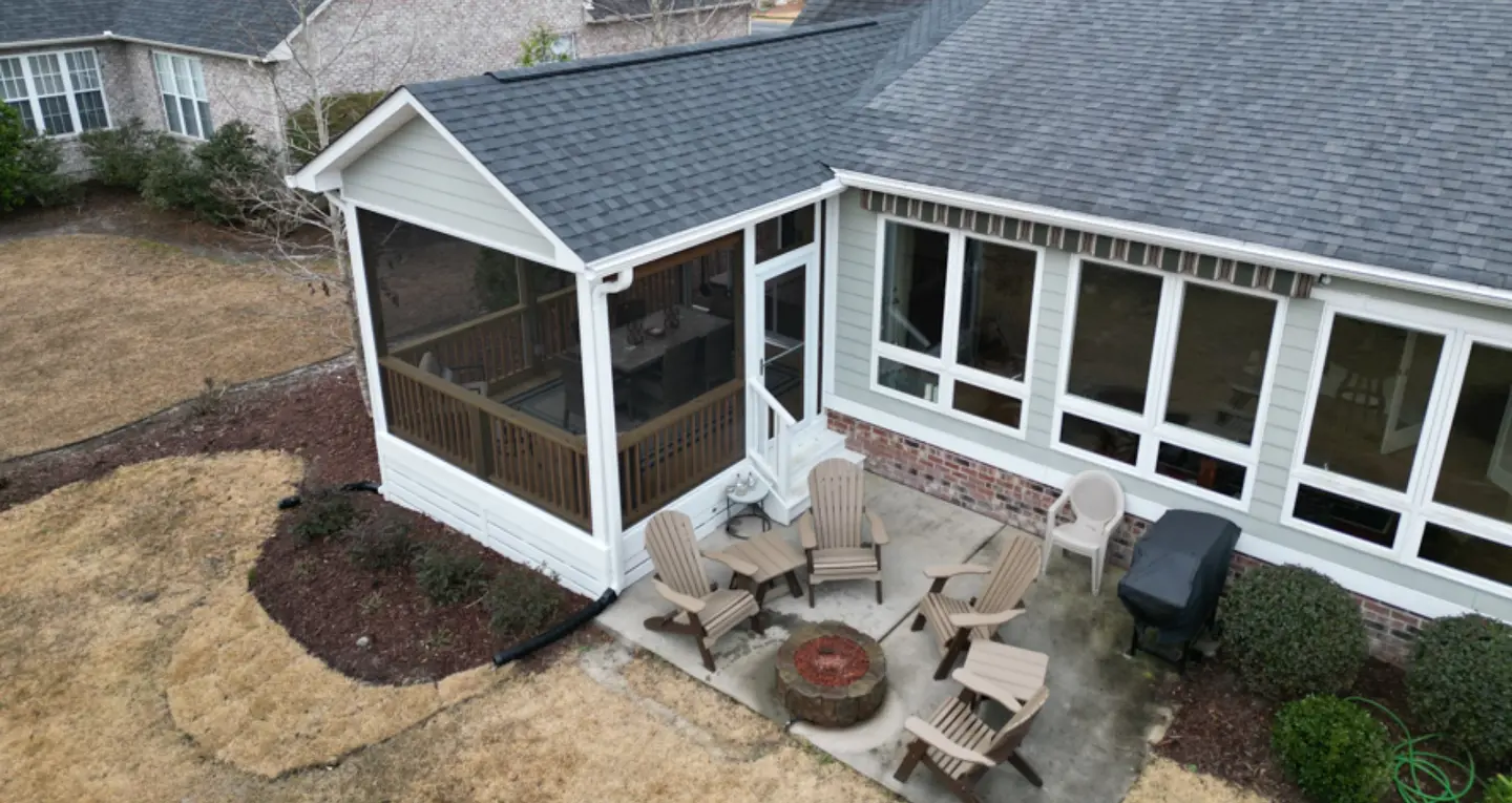 Residential screened porch installation with firepit and chairs in wilmington nc